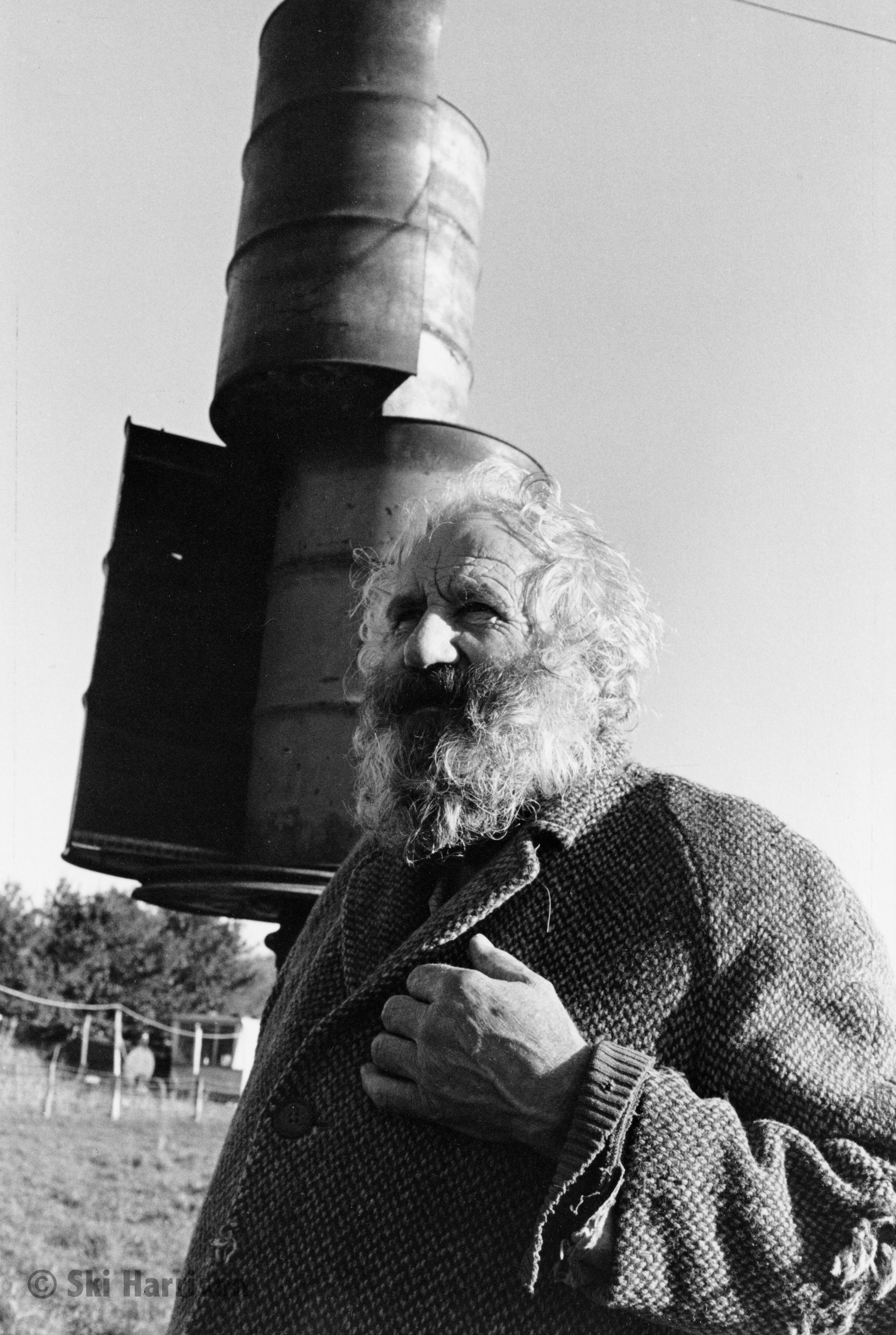 CS78 - Philip White in his 60s with his wind generator behind. Philip had a pig farm and afterwards chickens and a goat. Allaleigh, 1999